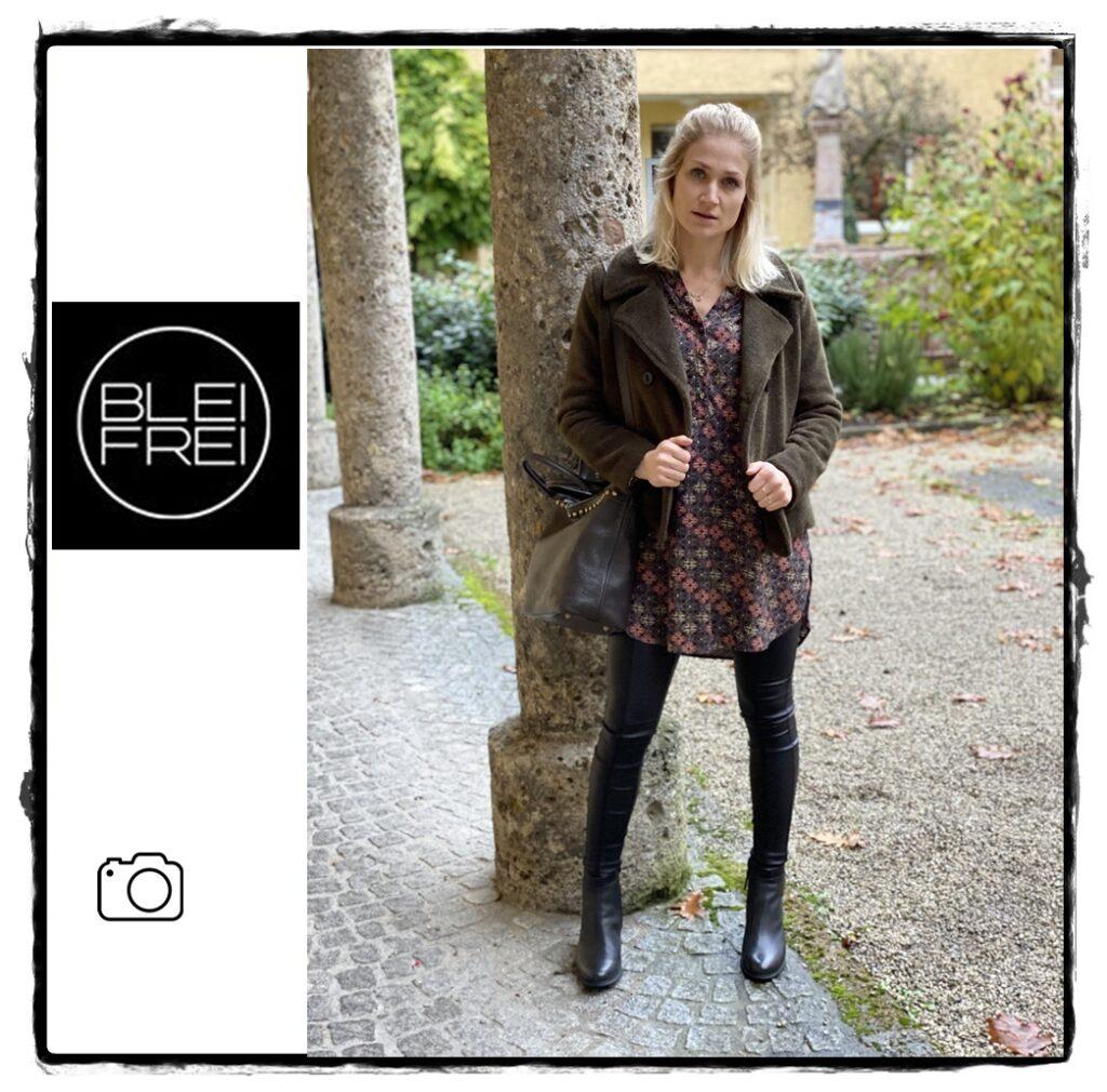 Dame im modischen Outfit vor Säulen in einem Garten